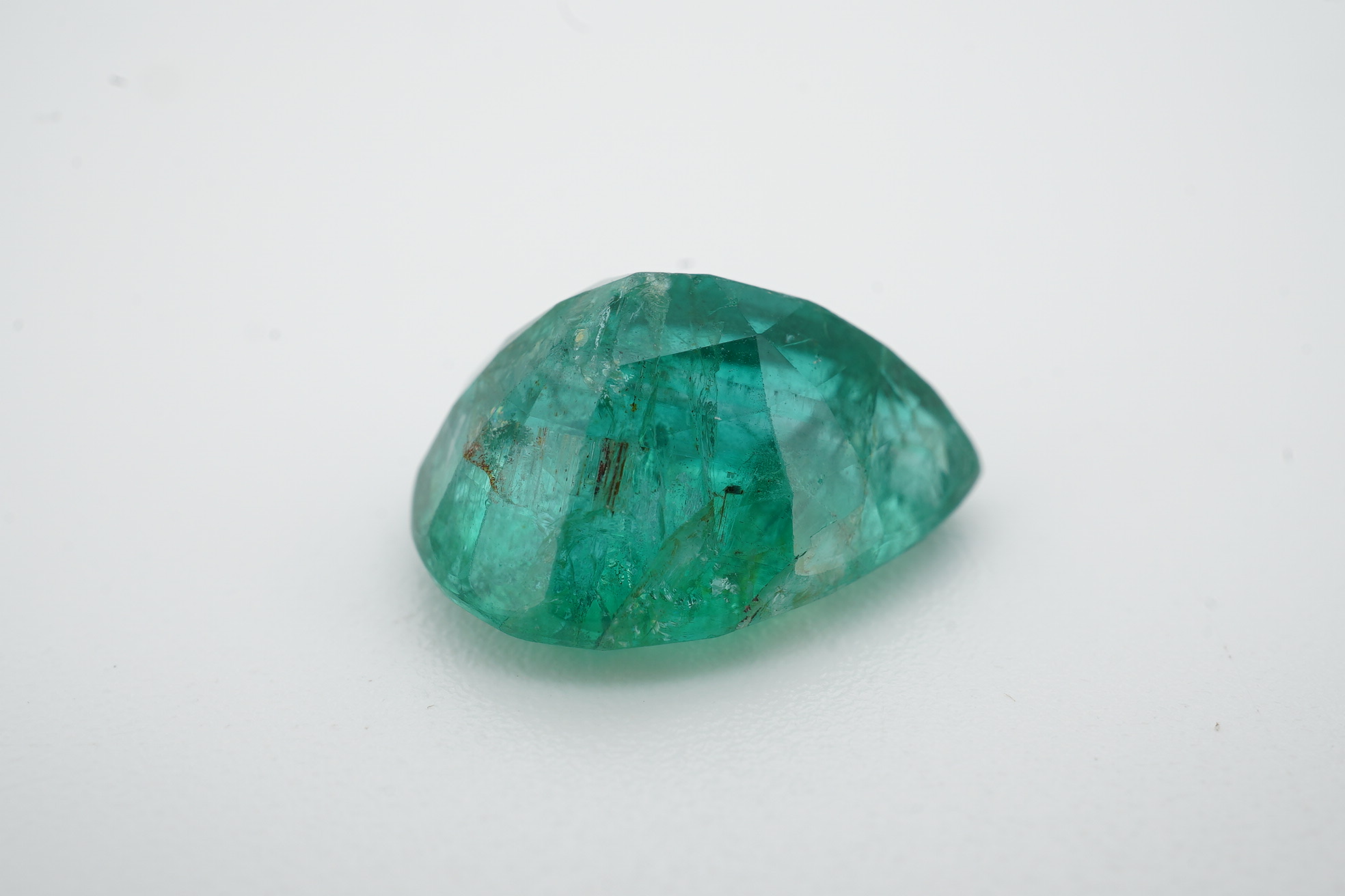 An unmounted pear cut emerald, weighing 6.32ct. Condition - poor to fair